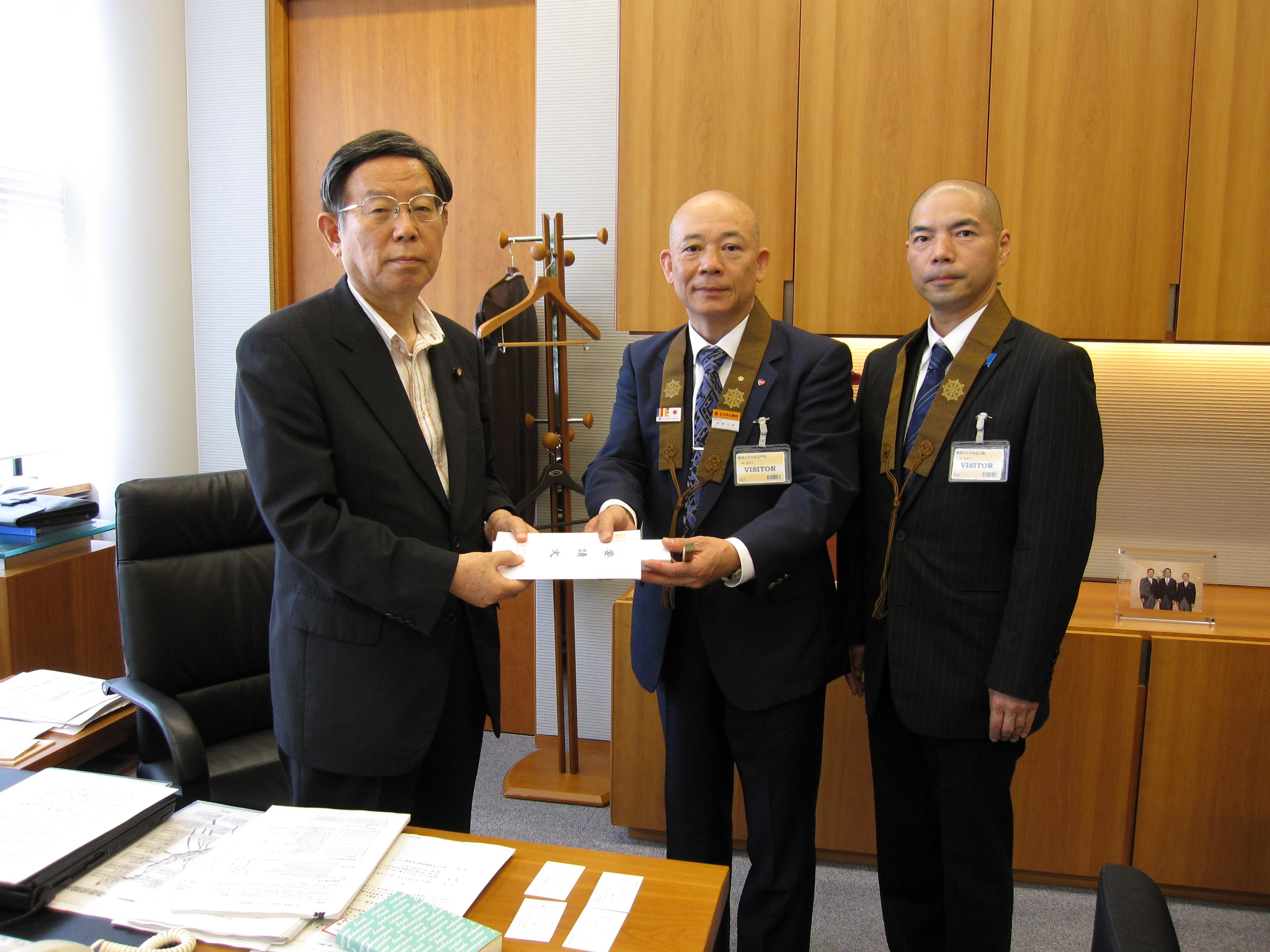 浅野勝人内閣官房副長官（左）へ深澤信善事務総長（中央）及び深真樹社会人権審議会副委員長（右）が中止要請文を手交